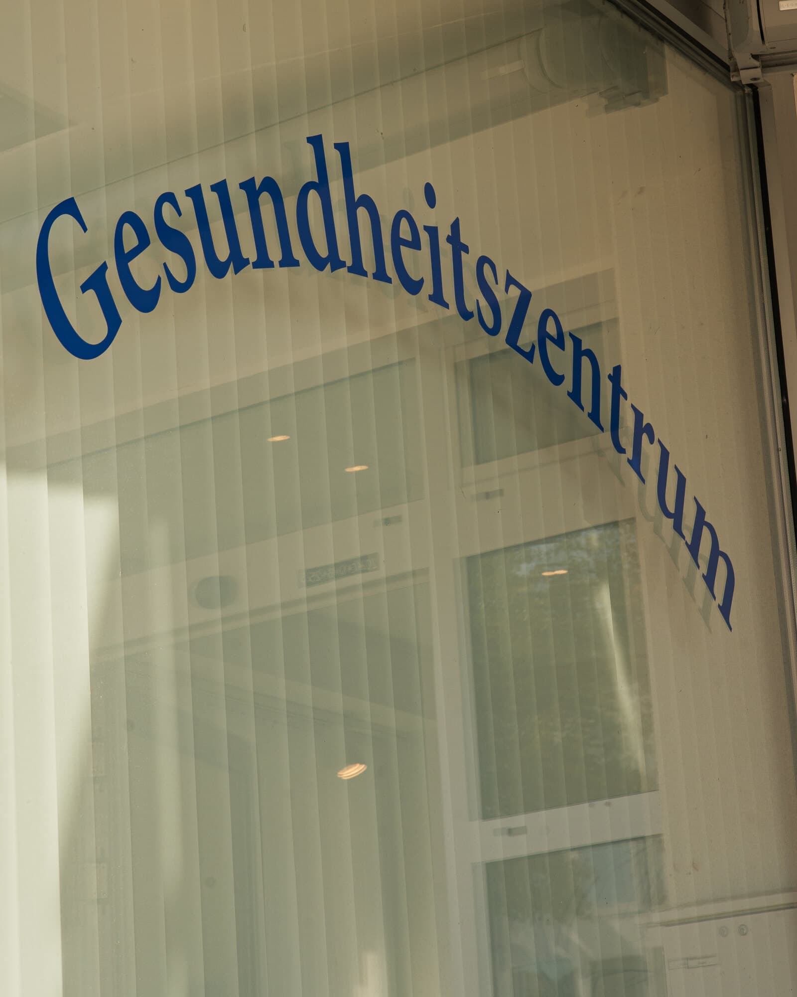 The lettering Gesundheitszentrum on the glass front of the practice
